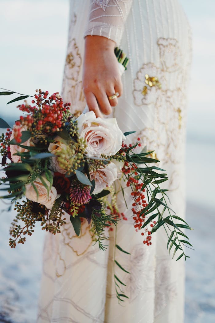 A bride holding a beautiful floral bouquet, showcasing elegance and tradition on her wedding day.